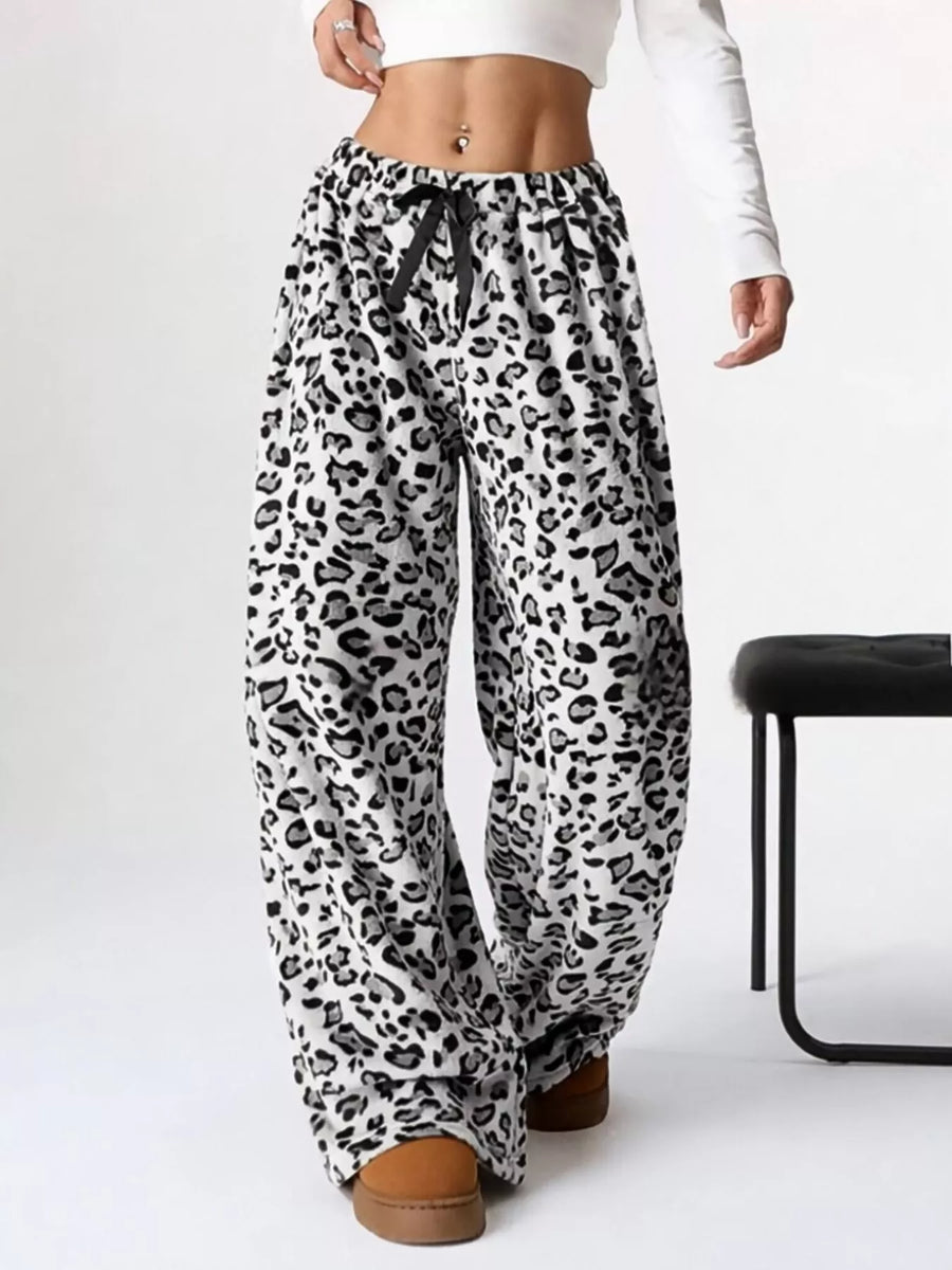 Leopard print pants worn by a person on a white background