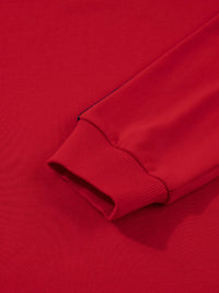Close-up of a red sweatshirt sleeve on a matching red background