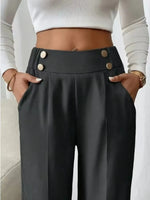 Person wearing black high-waisted pants with button details and a white cropped top.