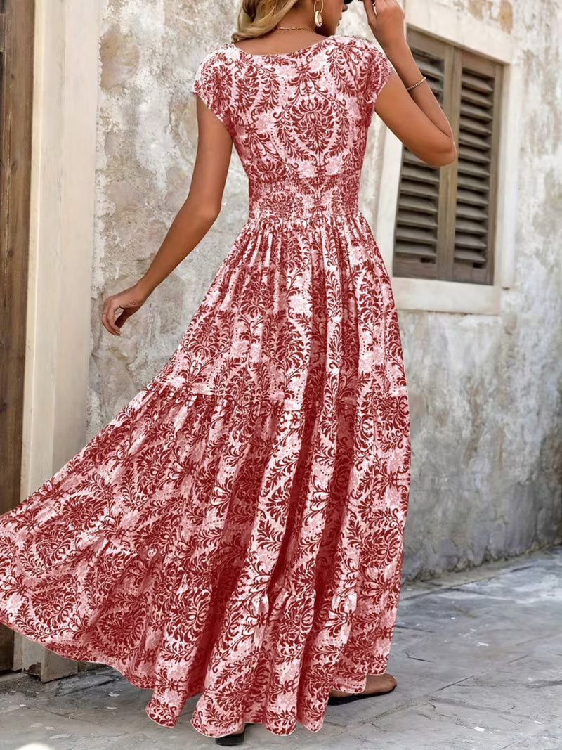 Woman wearing a red and white floral dress in an outdoor setting.