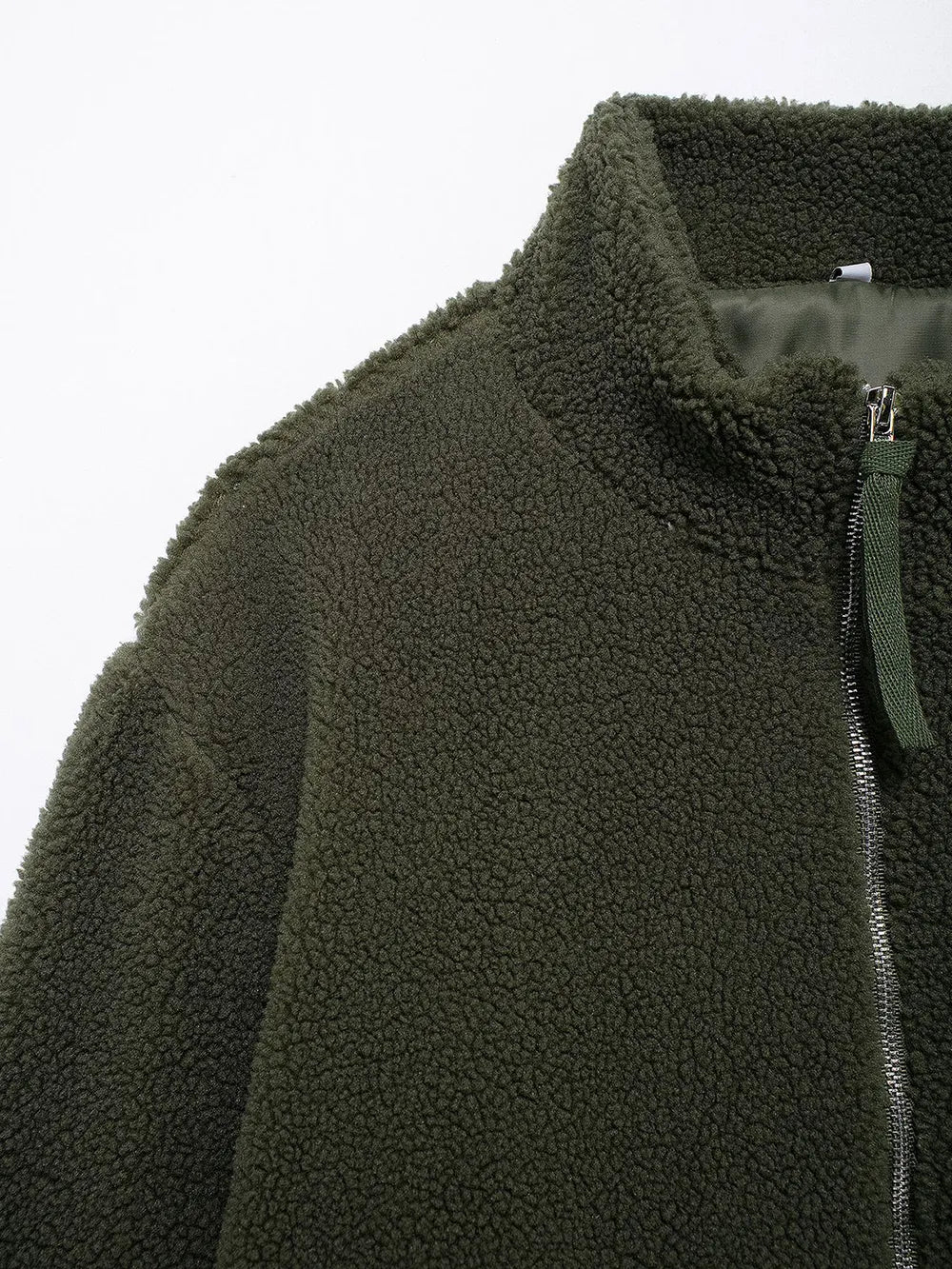 Close-up of a green fleece jacket with a zipper on a white background