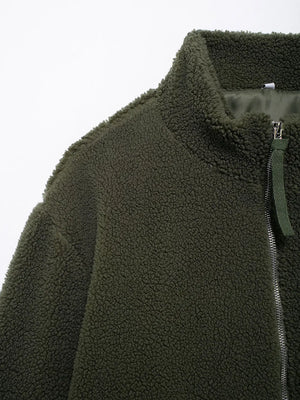 Close-up of a green fleece jacket with a zipper on a white background