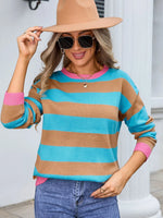 Woman wearing a colorful striped sweater and hat indoors