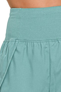 Close-up of a teal skirt with a plain background
