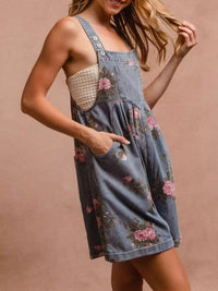 Woman wearing a denim dress with floral patterns on a beige background