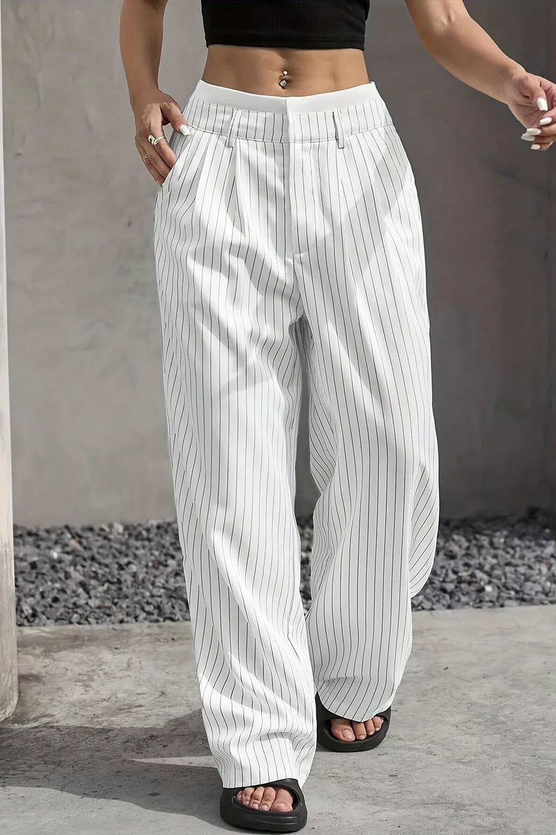 White wide-leg pinstripe pants with a relaxed, baggy fit, worn by a model in black slide sandals against a concrete wall background.