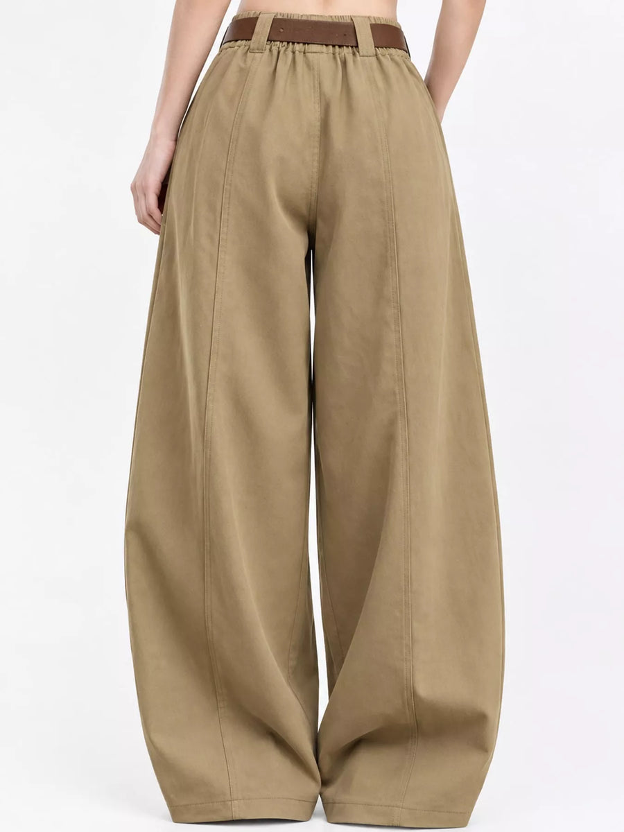 A person wearing wide-leg khaki pants with a brown belt, shown from the back against a plain white studio background.