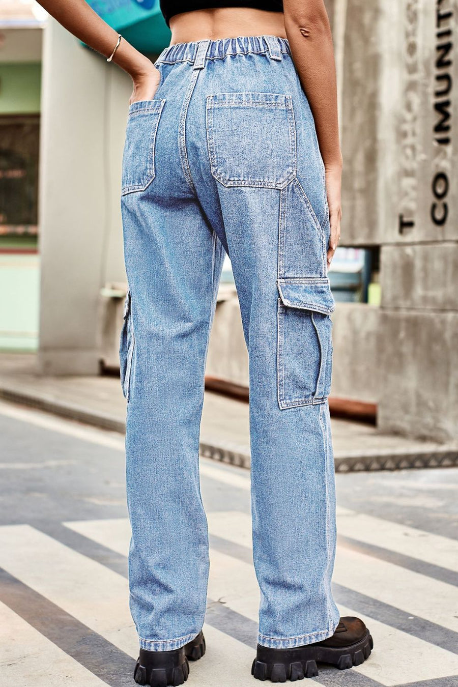 Person wearing light blue cargo jeans on a city street.
