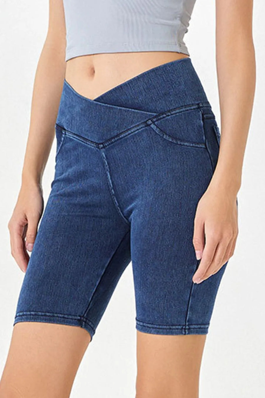 Person wearing blue denim shorts on a white background