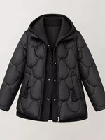 A black quilted puffer jacket with a hood, shown on a light gray background. The jacket features a wavy quilted pattern, a ribbed knit hood, a front zipper and snap button closure, and side pockets.