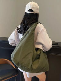 Person wearing a green bag over their shoulder in an indoor setting