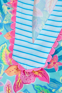 Striped fabric with pink scalloped edge on a colorful floral background