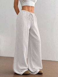 White wide-leg pants worn by a person on a plain background