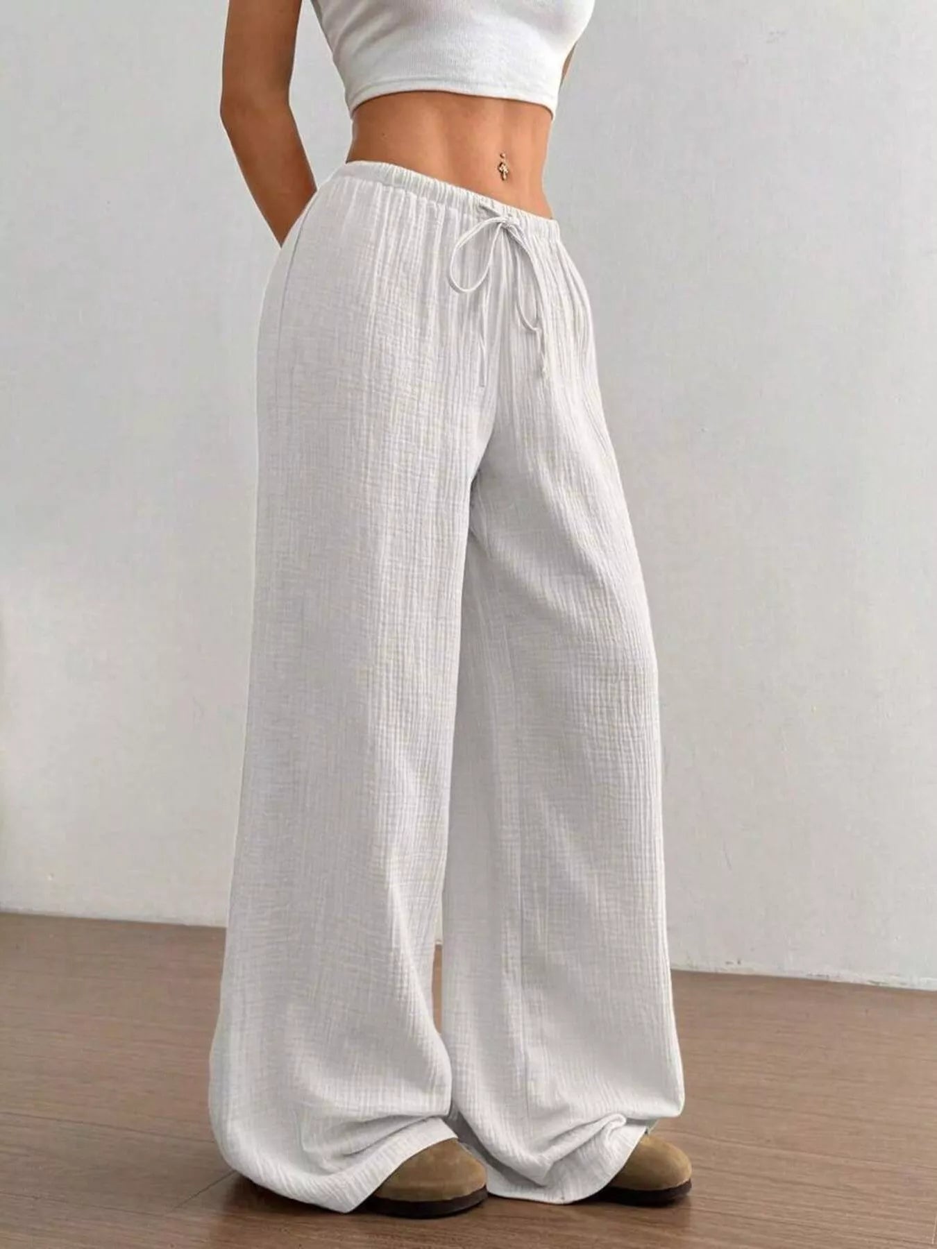 White wide-leg pants worn by a person on a plain background