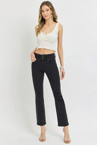 Woman wearing a white lace top and black jeans on a white background