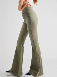Green flared jeans worn by a person on a white background
