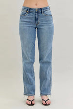 Blue jeans worn by a person on a plain background