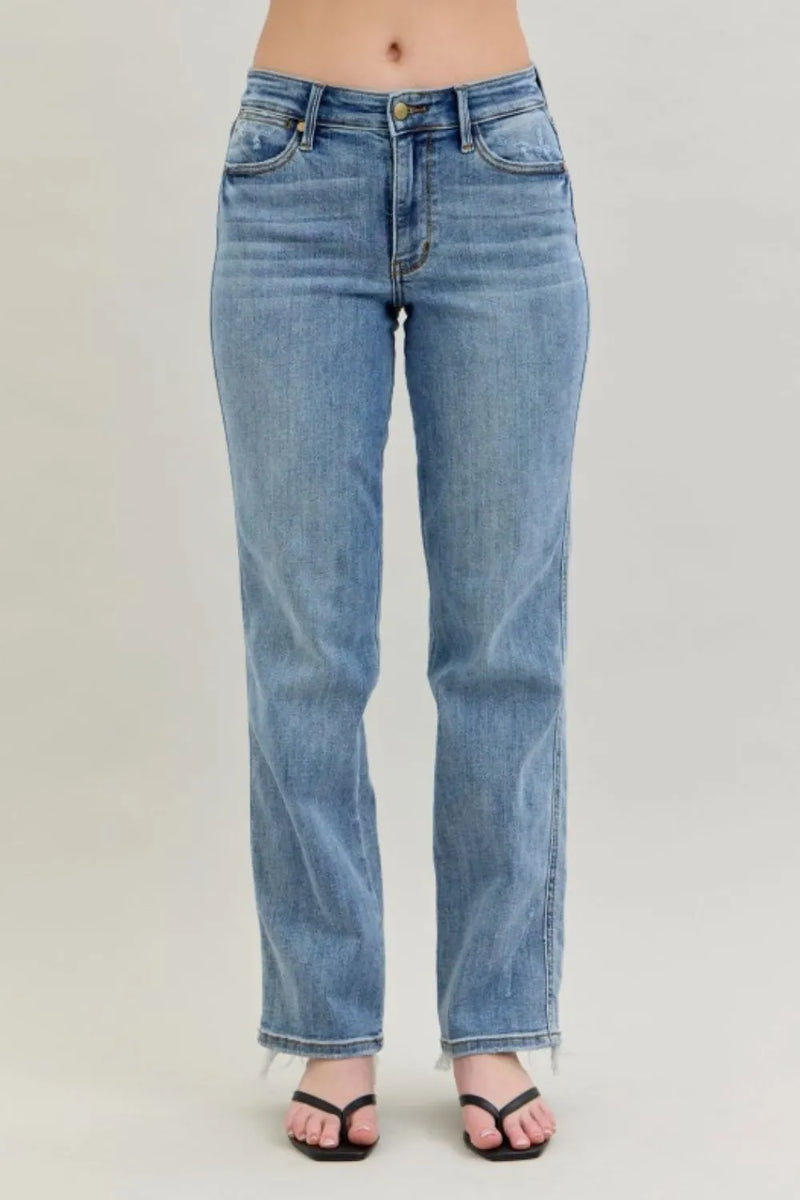 Blue jeans worn by a person on a plain background