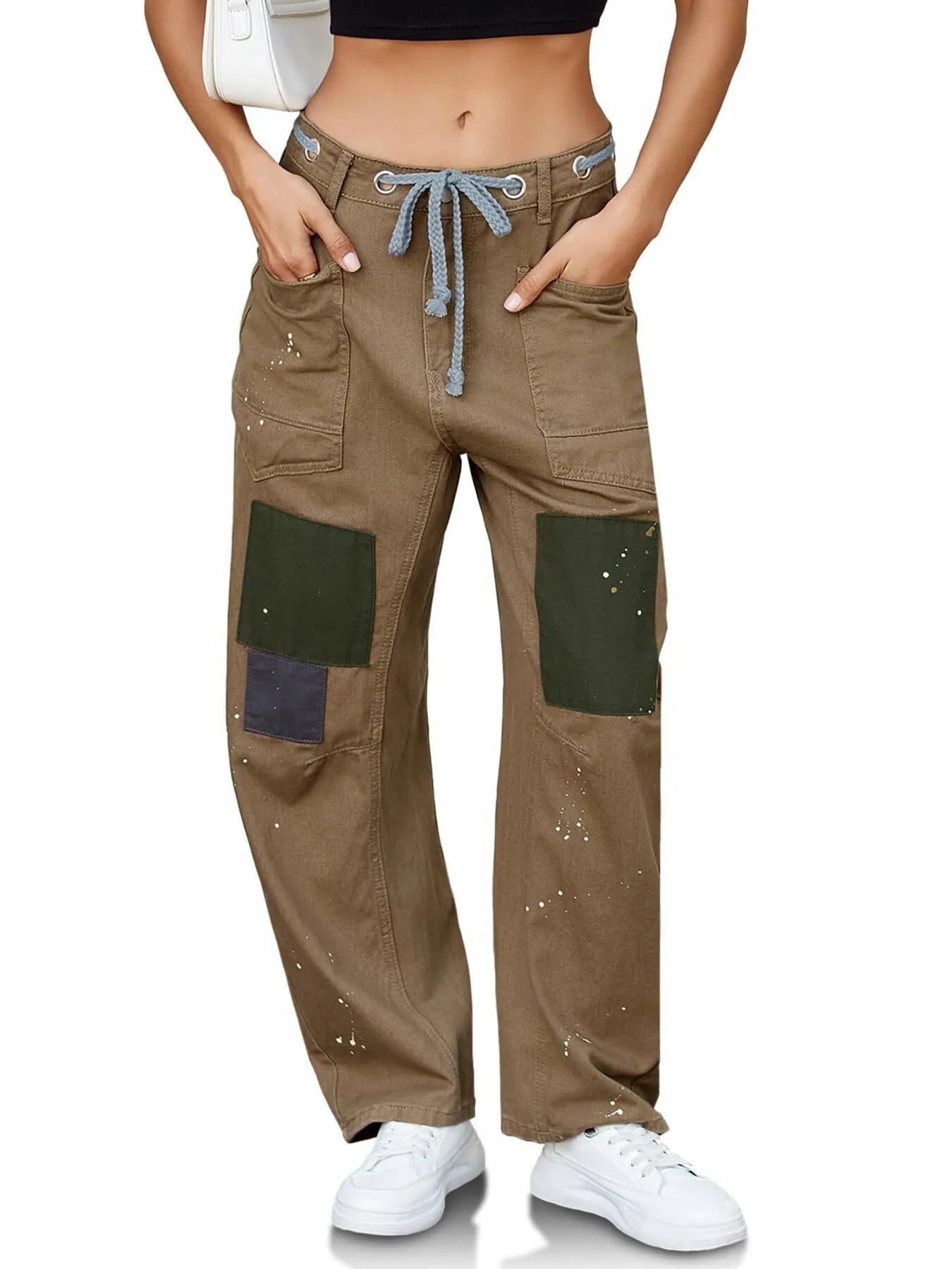 Brown cargo pants with green patches worn by a person on a white background