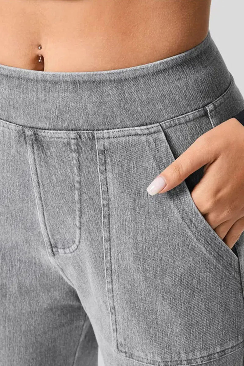 Gray jogger pants with a hand in the pocket against a neutral background