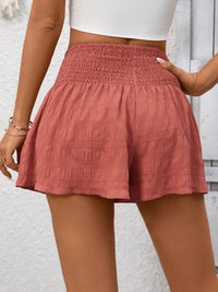 Person wearing pink shorts with a white background