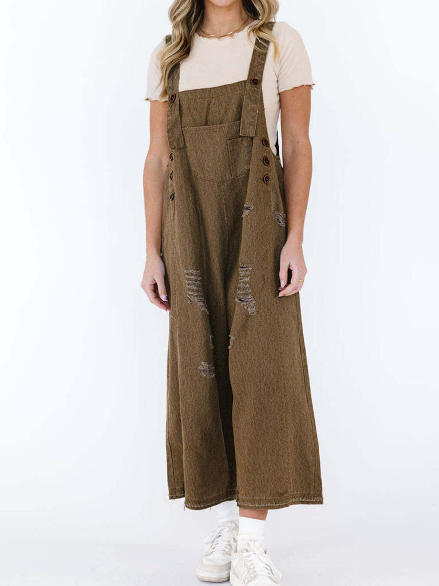Person wearing brown denim overalls on a white background