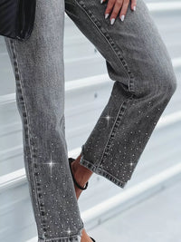 Gray jeans with rhinestone embellishments on a neutral background
