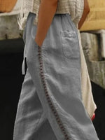 Person wearing a light blue skirt with decorative stitching detail.