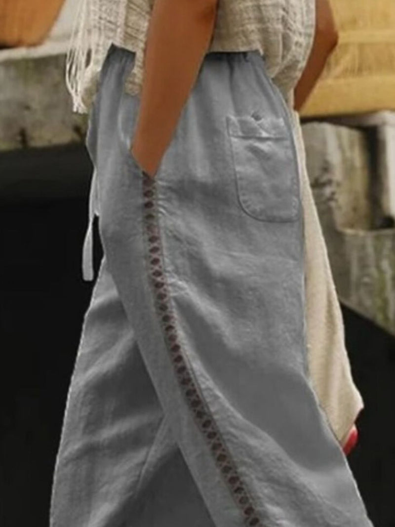 Person wearing a light blue skirt with decorative stitching detail.