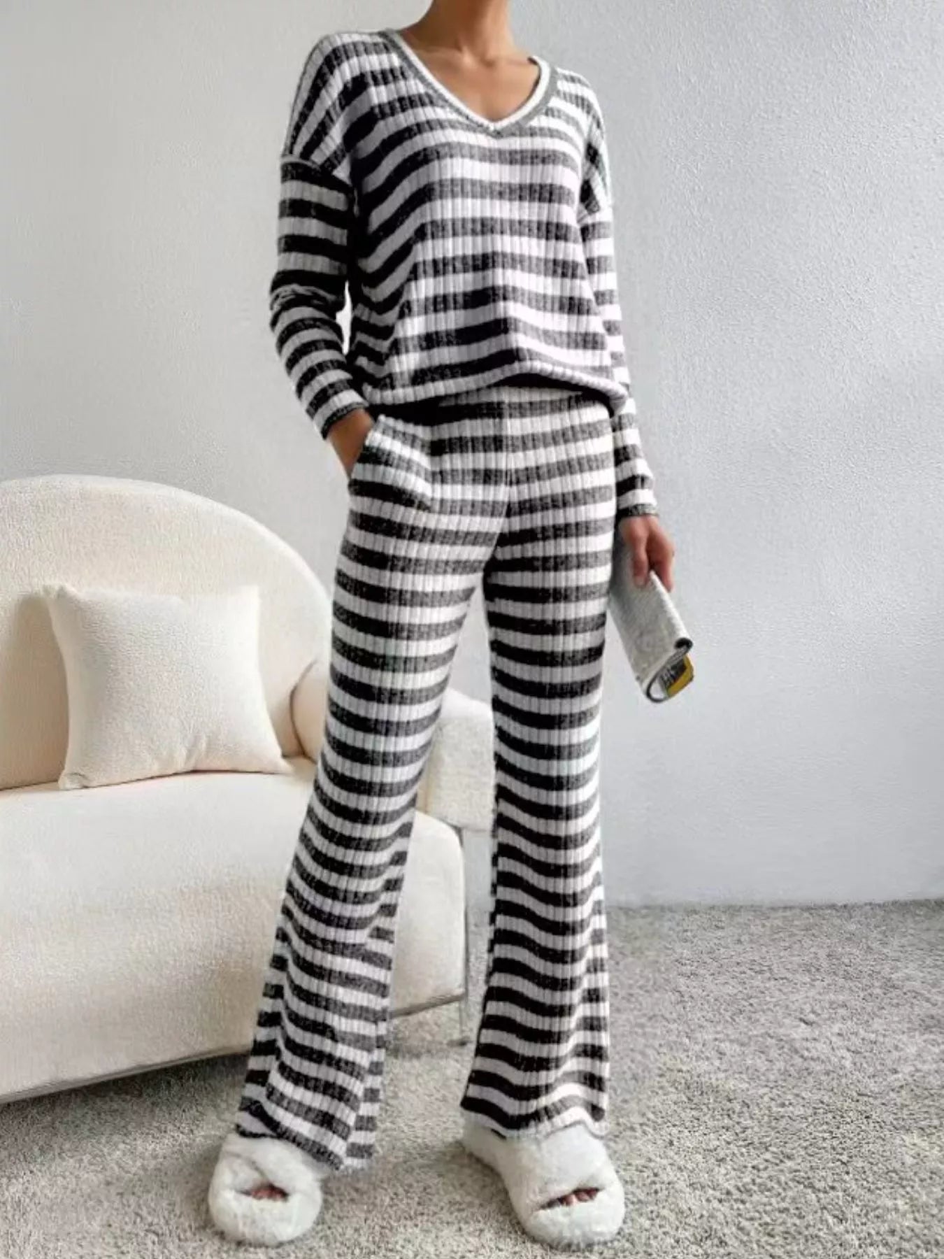 Person wearing a black and white striped pajama set in a living room.