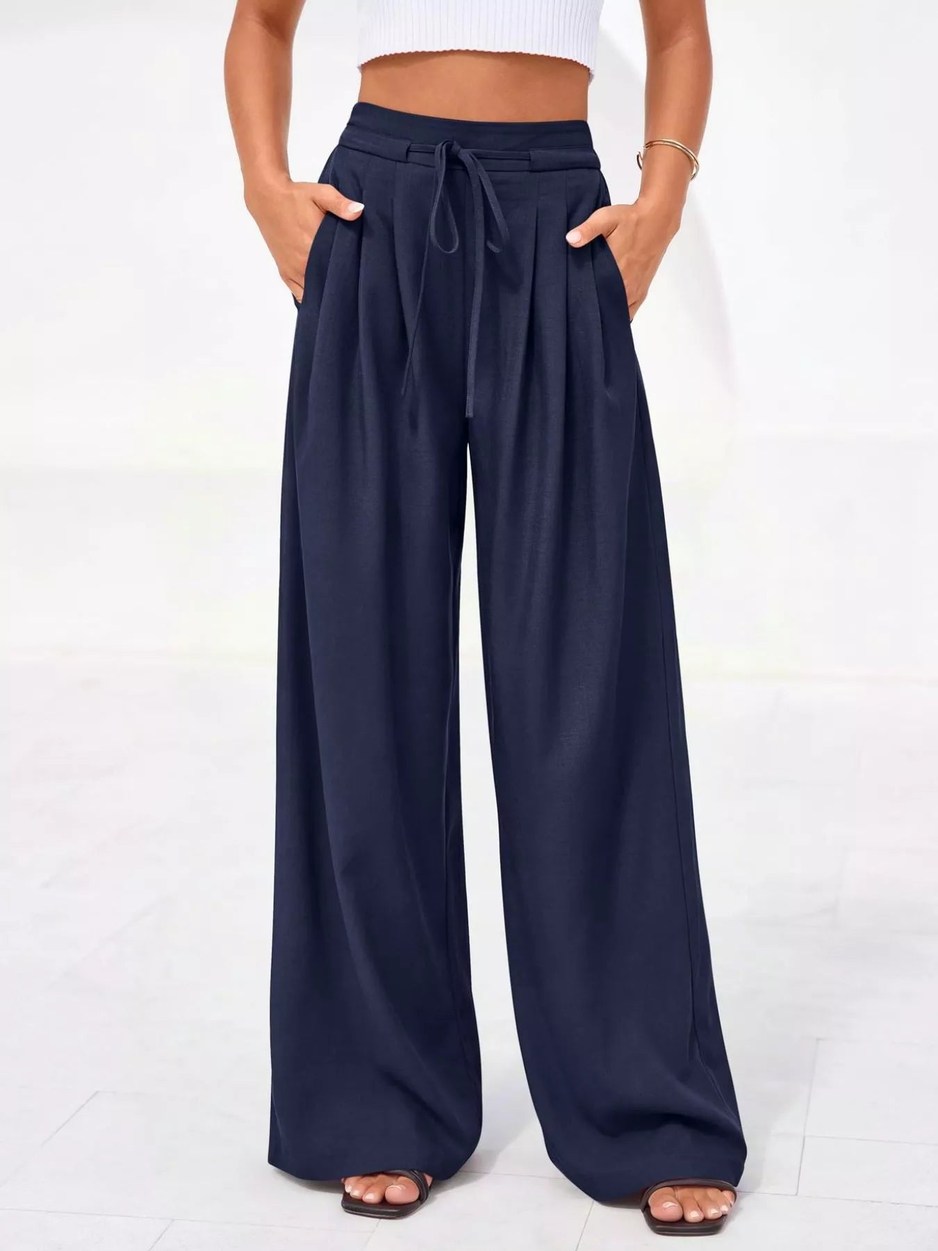 Navy wide-leg pants worn by a person on a white background