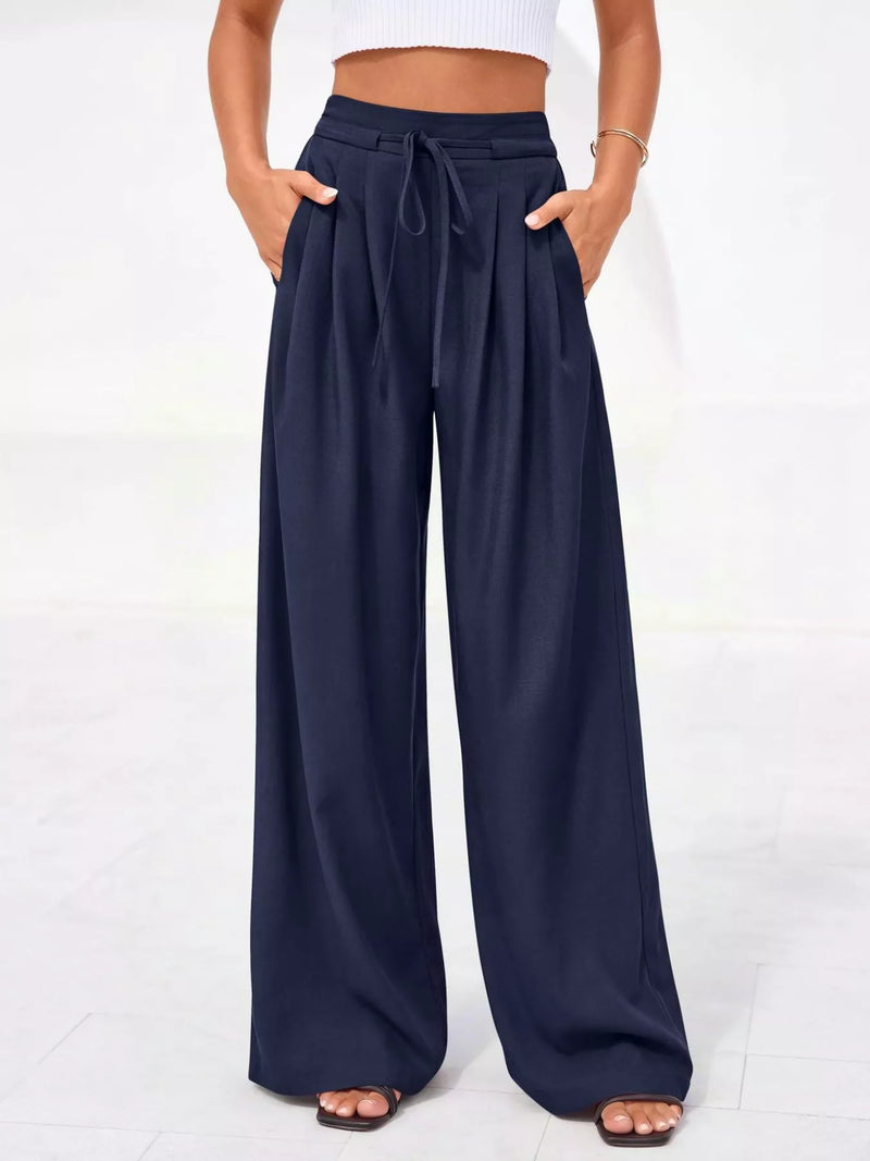 Navy wide-leg pants worn by a person on a white background