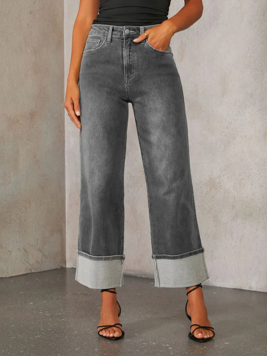 Person wearing gray wide-leg jeans against a neutral background