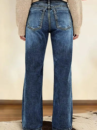 Person wearing blue flared jeans with a neutral background