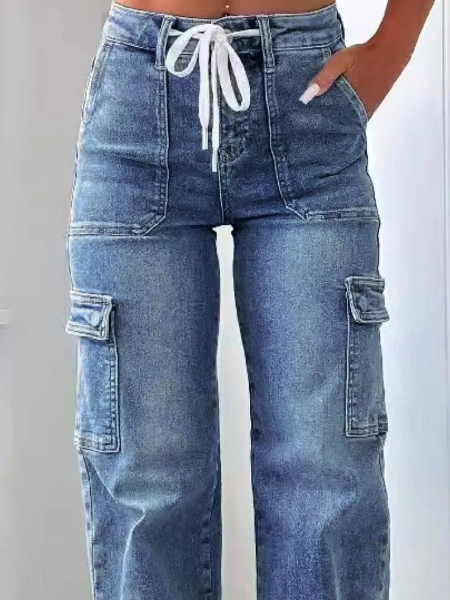 Blue cargo jeans with a white drawstring on a light gray background