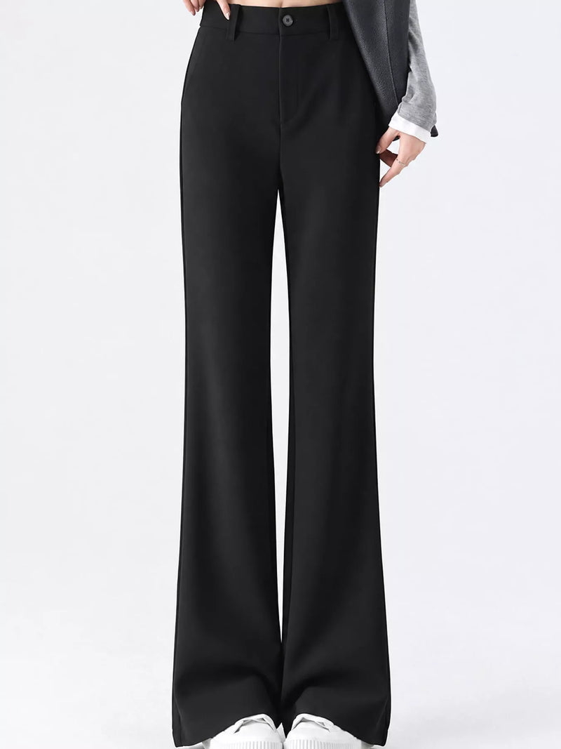 Black wide-leg trousers shown on a model from the waist down, styled with a gray blazer and white sneakers against a plain white studio background.