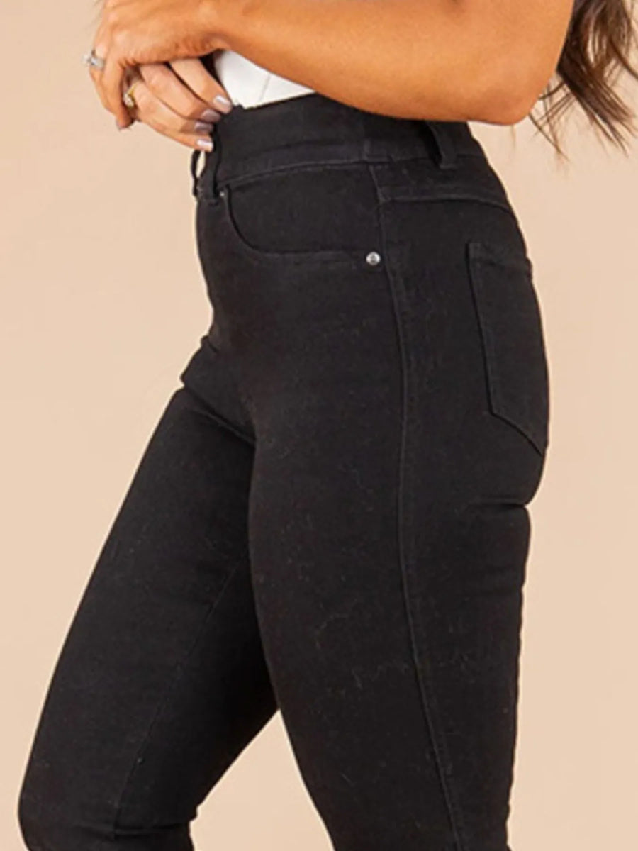 Black pants worn by a person on a beige background