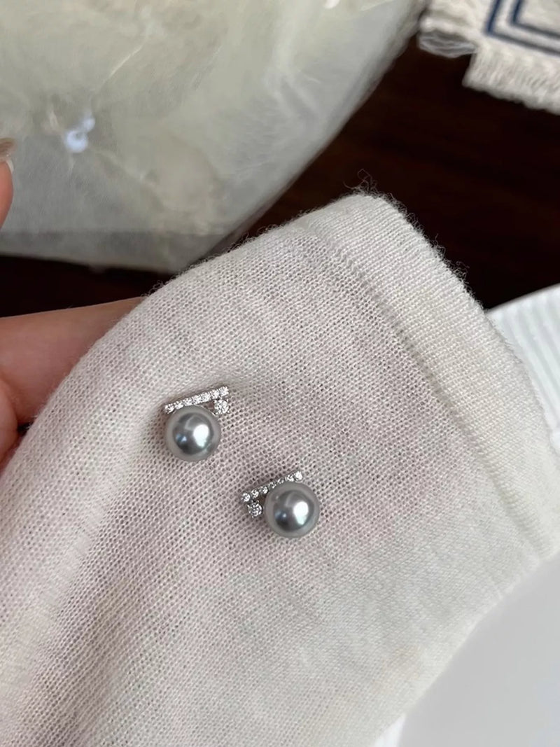 Silver earrings with pearls on a textured surface