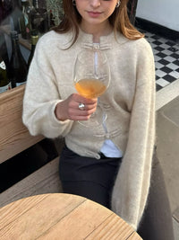 Woman holding a glass of wine in an outdoor setting