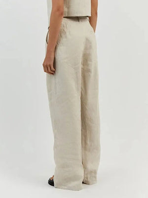 Beige linen pants worn by a person on a white background