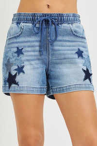 Denim shorts with star patterns on a plain background