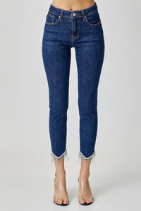 Blue jeans with fringe details on a white background