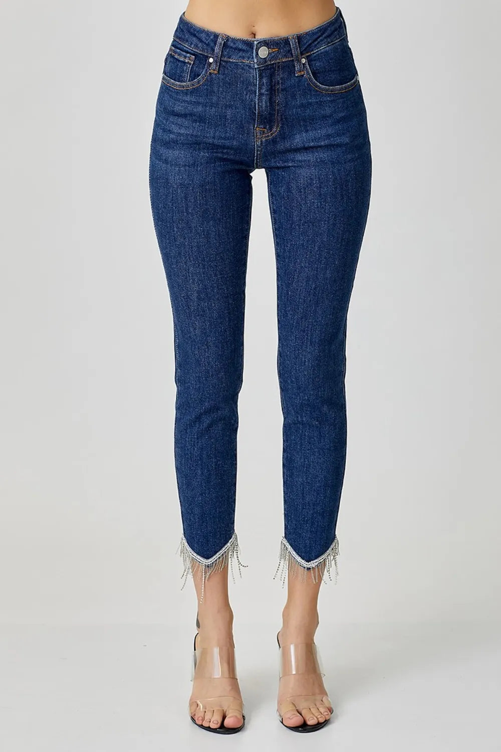 Blue jeans with fringe details on a white background