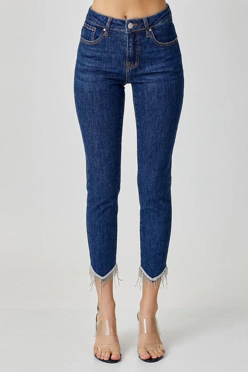 Blue jeans with fringe details on a white background