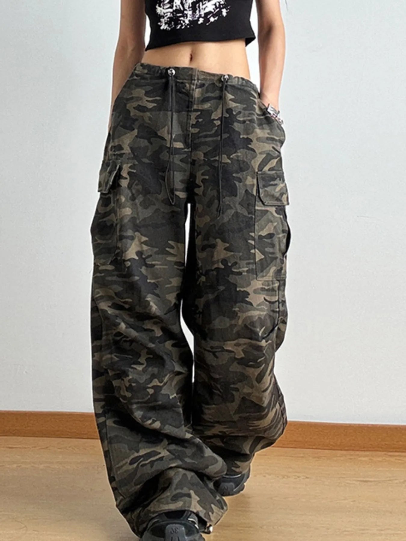 Camouflage cargo pants worn by a person on a plain background