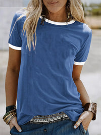 Person wearing a blue t-shirt with white trim outdoors