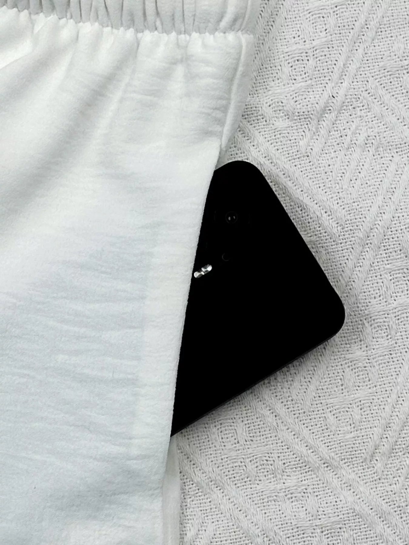 Black smartphone on a textured white surface