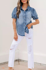Woman wearing a denim shirt and white pants against a light background