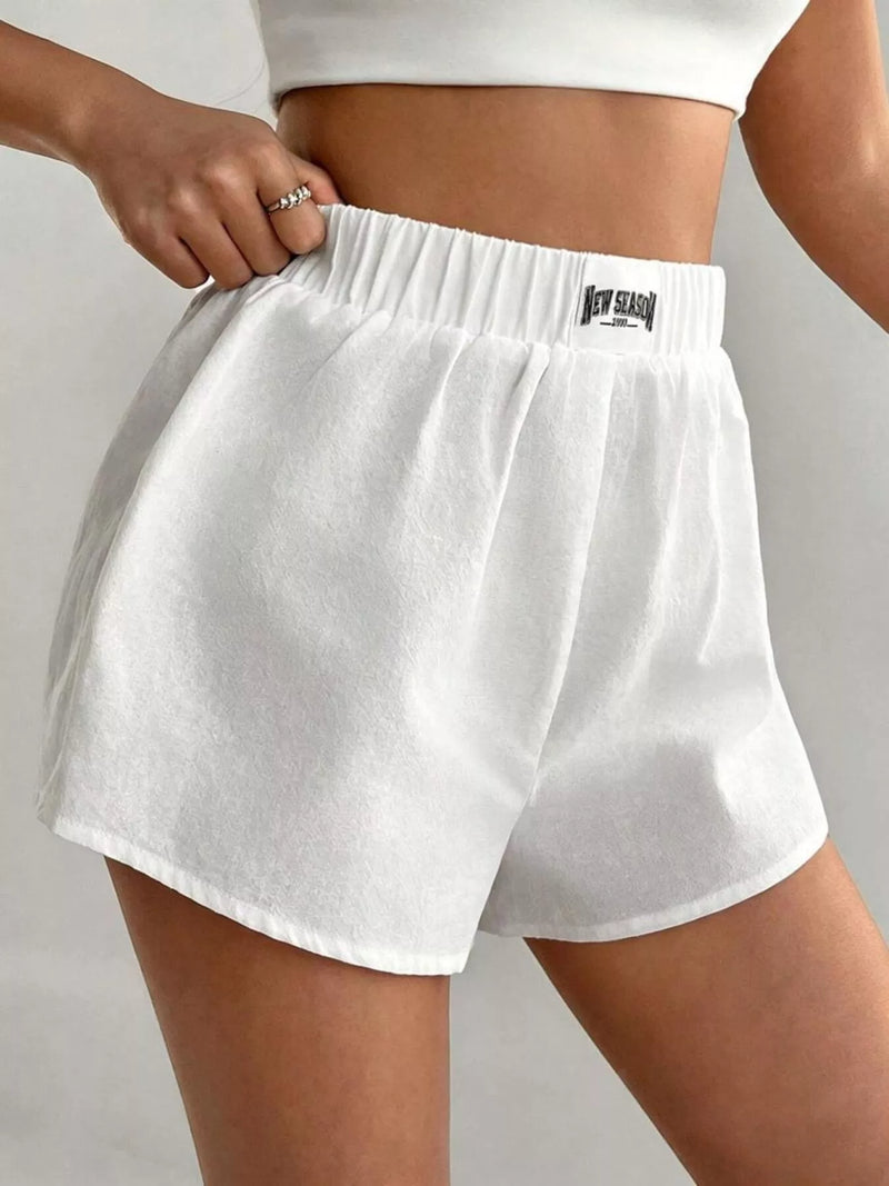 White shorts with a brand logo on a plain background