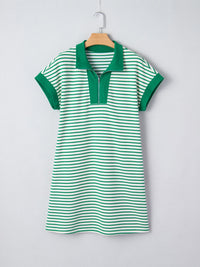 Green and white striped dress on a hanger against a light gray background